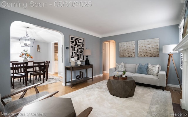2029 Hubbell St, Dearborn, MI 48128 - living area with arched walkways, wood finished floors, a chandelier, and baseboards