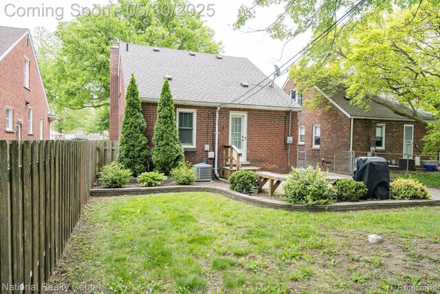 2029 Hubbell St, Dearborn, MI 48128 - rear view of property featuring a chimney, brick siding, a shingled roof, and central AC unit