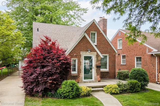2029 Hubbell St, Dearborn, MI 48128 - english style home featuring a chimney, a shingled roof, and brick siding