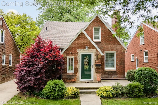 2029 Hubbell St, Dearborn, MI 48128 - tudor-style house with a chimney, roof with shingles, and brick siding
