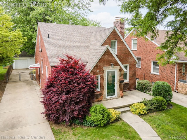 2029 Hubbell St, Dearborn, MI 48128 - english style home featuring a chimney, a shingled roof, a gate, a garage, and brick siding
