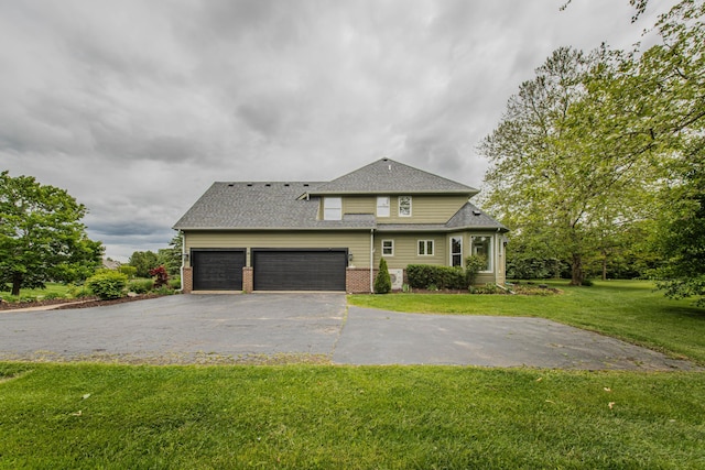 9117 Cambridge Dr, Saline, MI 48176 - view of front of home with driveway, brick siding, a front lawn, a garage, and a shingled roof
