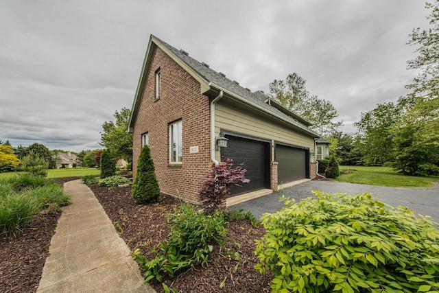 9117 Cambridge Dr, Saline, MI 48176 - view of home's exterior with brick siding, driveway, and an attached garage