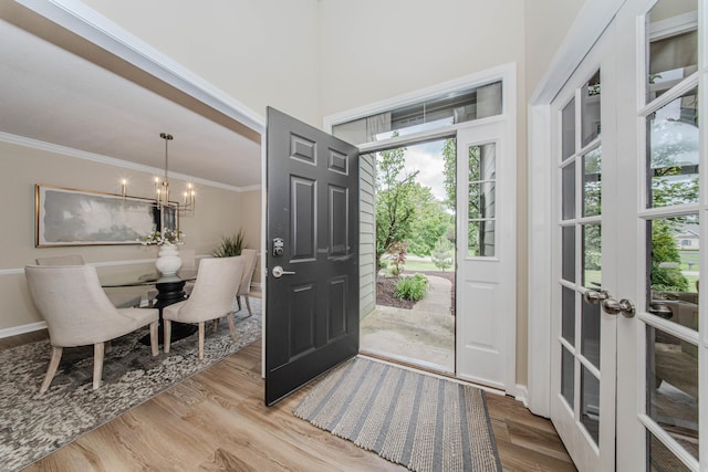9117 Cambridge Dr, Saline, MI 48176 - foyer with a chandelier, wood finished floors, ornamental molding, and french doors