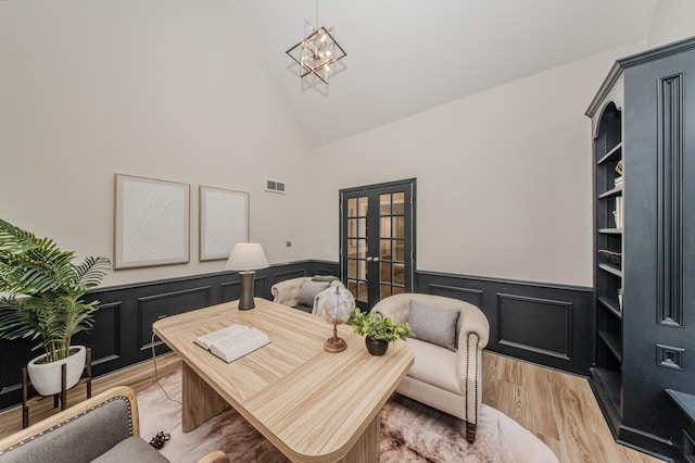 9117 Cambridge Dr, Saline, MI 48176 - office featuring french doors, wainscoting, high vaulted ceiling, light wood finished floors, and a chandelier