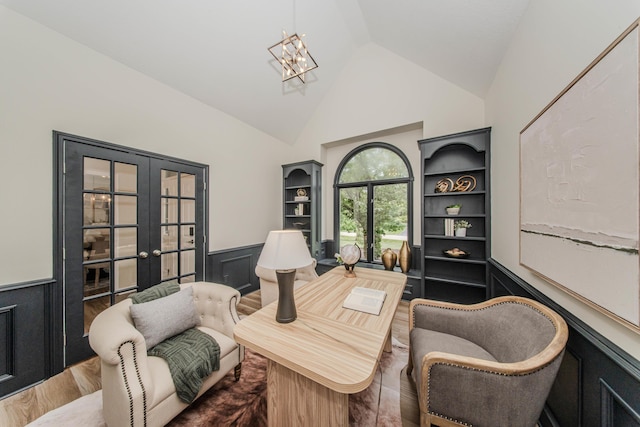9117 Cambridge Dr, Saline, MI 48176 - sitting room with a wainscoted wall, french doors, wood finished floors, high vaulted ceiling, and a chandelier