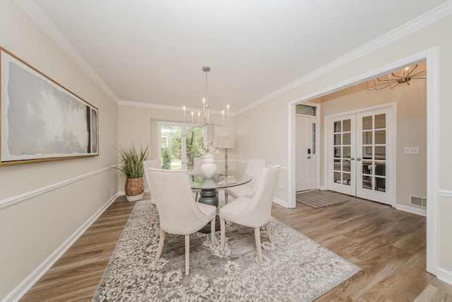 9117 Cambridge Dr, Saline, MI 48176 - dining area featuring a chandelier, french doors, light wood-style floors, ornamental molding, and baseboards