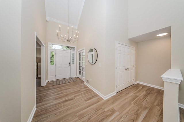 9117 Cambridge Dr, Saline, MI 48176 - entrance foyer featuring high vaulted ceiling, crown molding, a chandelier, baseboards, and light wood-style flooring