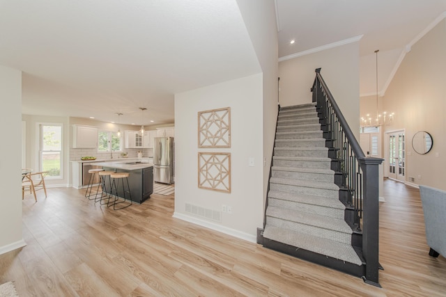 9117 Cambridge Dr, Saline, MI 48176 - staircase featuring wood finished floors, plenty of natural light, a chandelier, baseboards, and recessed lighting