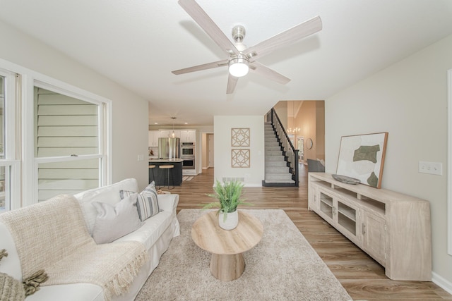 9117 Cambridge Dr, Saline, MI 48176 - living area with stairway, light wood finished floors, baseboards, and a ceiling fan