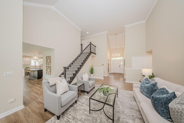 9117 Cambridge Dr, Saline, MI 48176 - living room with light wood finished floors, a chandelier, stairway, high vaulted ceiling, and baseboards