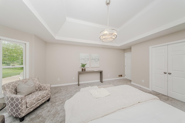 9117 Cambridge Dr, Saline, MI 48176 - bedroom with a tray ceiling, light carpet, a chandelier, and baseboards