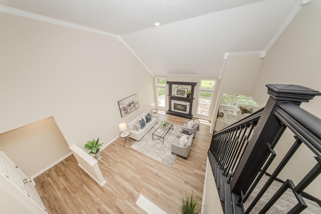 9117 Cambridge Dr, Saline, MI 48176 - living room with wood finished floors, baseboards, crown molding, lofted ceiling, and a fireplace