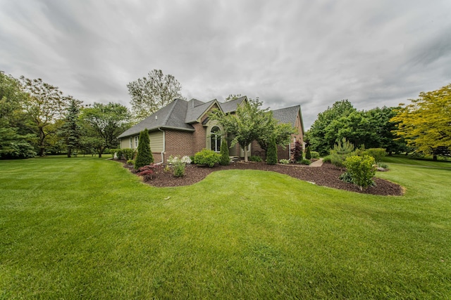 9117 Cambridge Dr, Saline, MI 48176 - view of front of home featuring brick siding, a front lawn, and a shingled roof