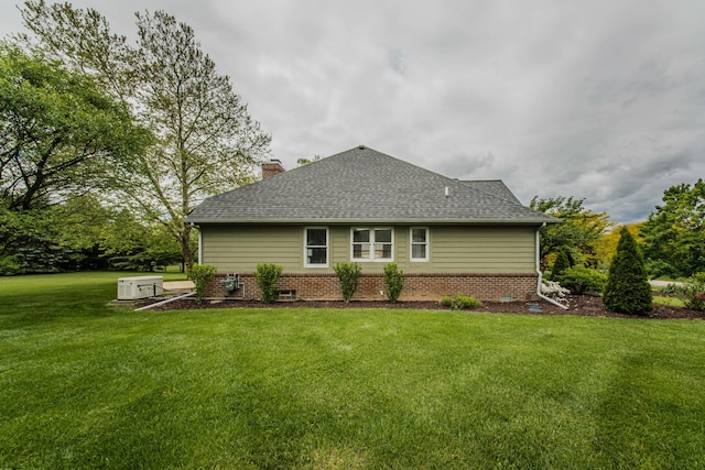 9117 Cambridge Dr, Saline, MI 48176 - back of property featuring a chimney, a yard, and roof with shingles