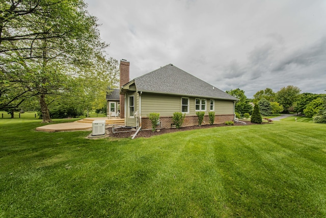 9117 Cambridge Dr, Saline, MI 48176 - back of property with a chimney, roof with shingles, a patio, and brick siding