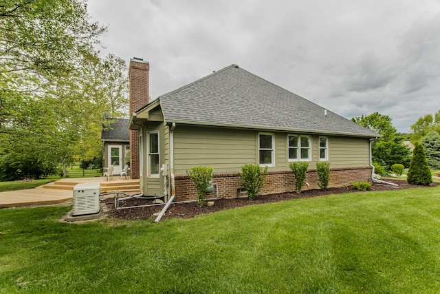 9117 Cambridge Dr, Saline, MI 48176 - rear view of property with a chimney, a yard, a shingled roof, and brick siding