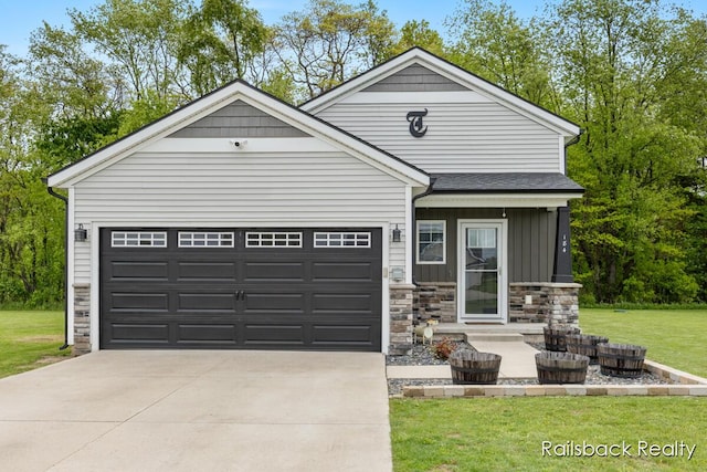 184 Dana Ln, Sand Lake, MI 49343 - view of front of property featuring stone siding, an attached garage, driveway, a front lawn, and board and batten siding