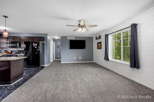 184 Dana Ln, Sand Lake, MI 49343 - unfurnished living room featuring ceiling fan, dark carpet, and baseboards