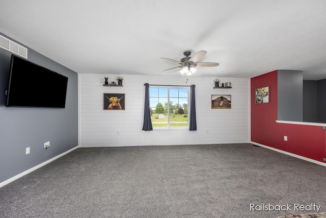 184 Dana Ln, Sand Lake, MI 49343 - unfurnished living room with ceiling fan, carpet, wood walls, and baseboards
