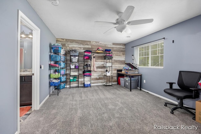 184 Dana Ln, Sand Lake, MI 49343 - home office featuring carpet, ceiling fan, wood walls, an accent wall, and baseboards