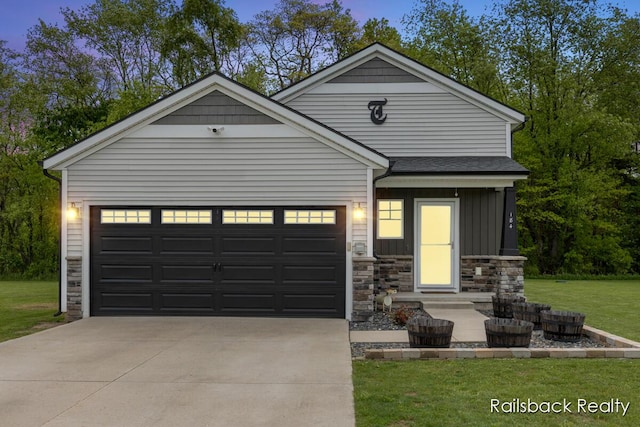 184 Dana Ln, Sand Lake, MI 49343 - view of front of property featuring stone siding, driveway, a garage, a front yard, and board and batten siding