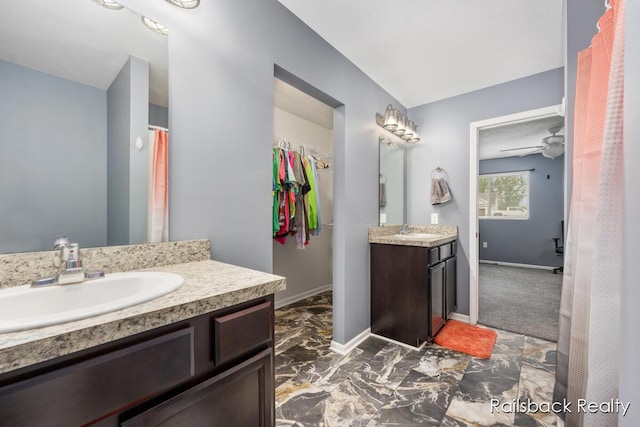 184 Dana Ln, Sand Lake, MI 49343 - full bathroom with two vanities, baseboards, marble finish flooring, and a walk in closet