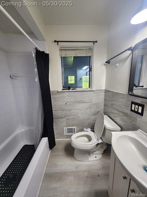 2625 Winston Dr, Sterling Heights, MI 48310 - bathroom with tile walls, toilet, wainscoting, shower / tub combo, and vanity