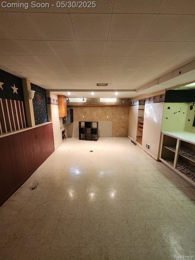 2625 Winston Dr, Sterling Heights, MI 48310 - finished below grade area featuring tile patterned floors, a drop ceiling, wooden walls, and wainscoting