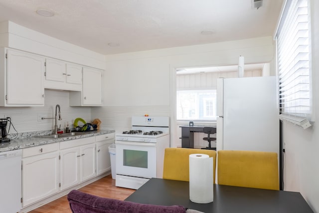 23067 Stauber Ave, Hazel Park, MI 48030 - kitchen with white appliances, a sink, white cabinetry, light wood-style floors, and backsplash
