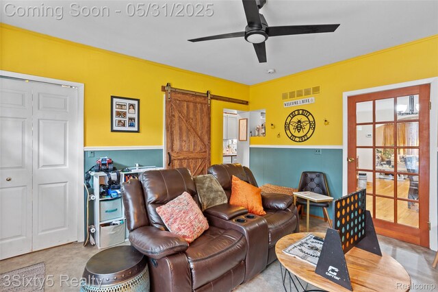 6568 Balfour Ave, Allen Park, MI 48101 - living area with a barn door, a ceiling fan, and a wainscoted wall