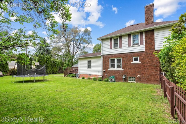 6568 Balfour Ave, Allen Park, MI 48101 - back of property with a trampoline, a chimney, a deck, and brick siding