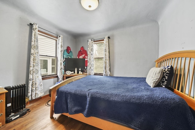 912 Gerald Ave, Jackson, MI 49203 - bedroom with multiple windows, wood finished floors, and radiator heating unit