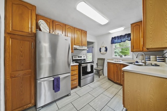 912 Gerald Ave, Jackson, MI 49203 - kitchen featuring appliances with stainless steel finishes, under cabinet range hood, a sink, light countertops, and brown cabinets