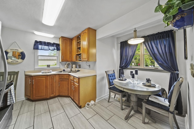 912 Gerald Ave, Jackson, MI 49203 - kitchen with a sink, brown cabinets, light countertops, and plenty of natural light