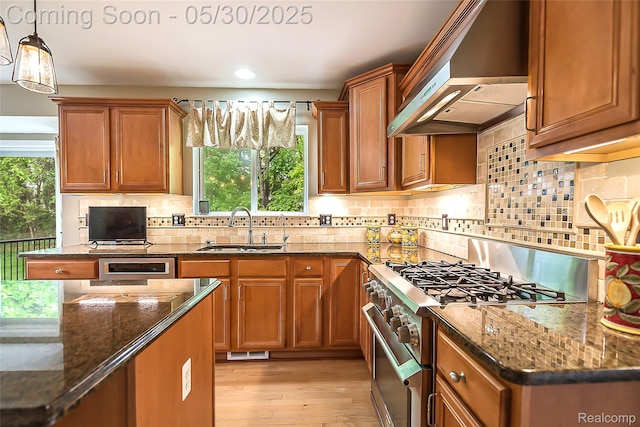 29811 Bradford Dr, New Hudson, MI 48165 - kitchen featuring high end range, wall chimney exhaust hood, a sink, brown cabinetry, and recessed lighting