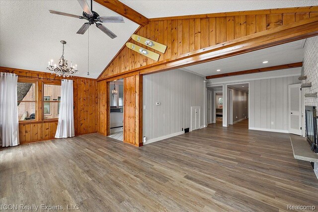 8569 Cooley Beach Dr, White Lake, MI 48386 - unfurnished living room with a chandelier, wooden walls, wood finished floors, a ceiling fan, and a fireplace