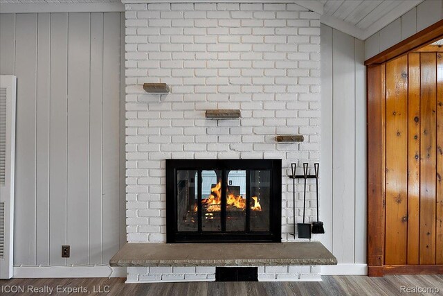8569 Cooley Beach Dr, White Lake, MI 48386 - detailed view of wood finished floors, a fireplace, wood walls, and baseboards
