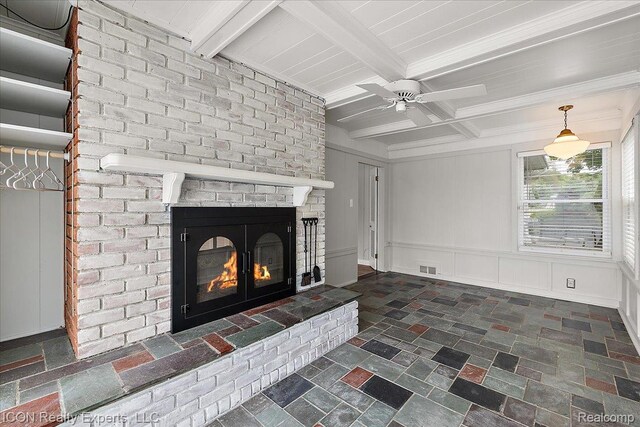8569 Cooley Beach Dr, White Lake, MI 48386 - unfurnished living room with a brick fireplace, beamed ceiling, ceiling fan, a decorative wall, and dark stone finish flooring