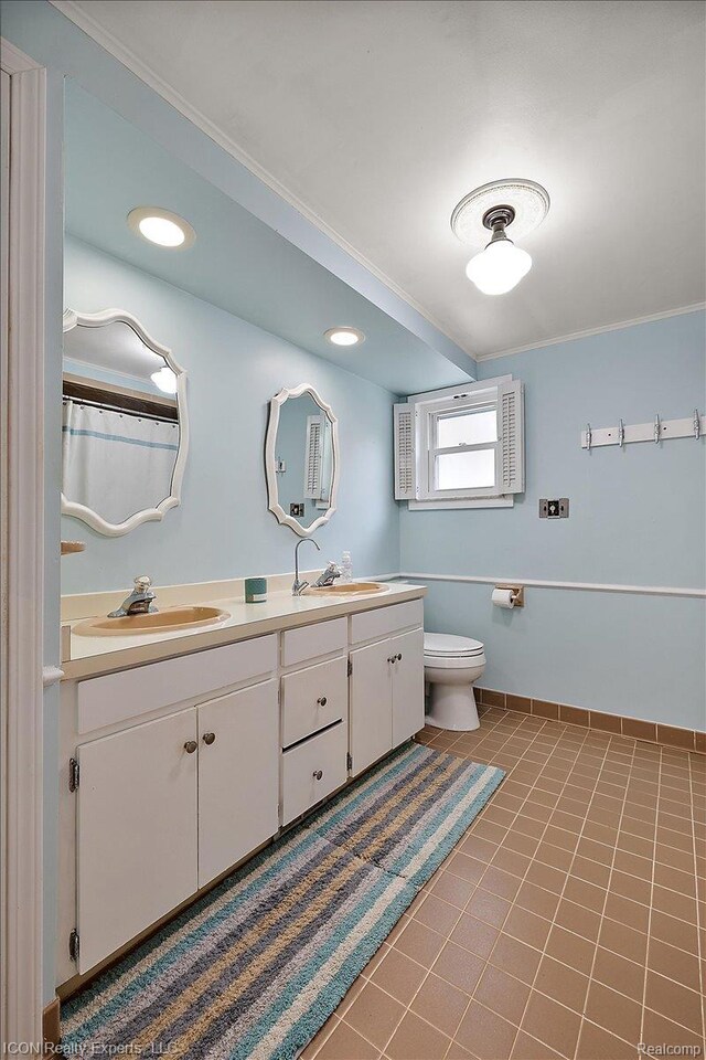 8569 Cooley Beach Dr, White Lake, MI 48386 - bathroom with double vanity, toilet, ornamental molding, tile patterned flooring, and baseboards