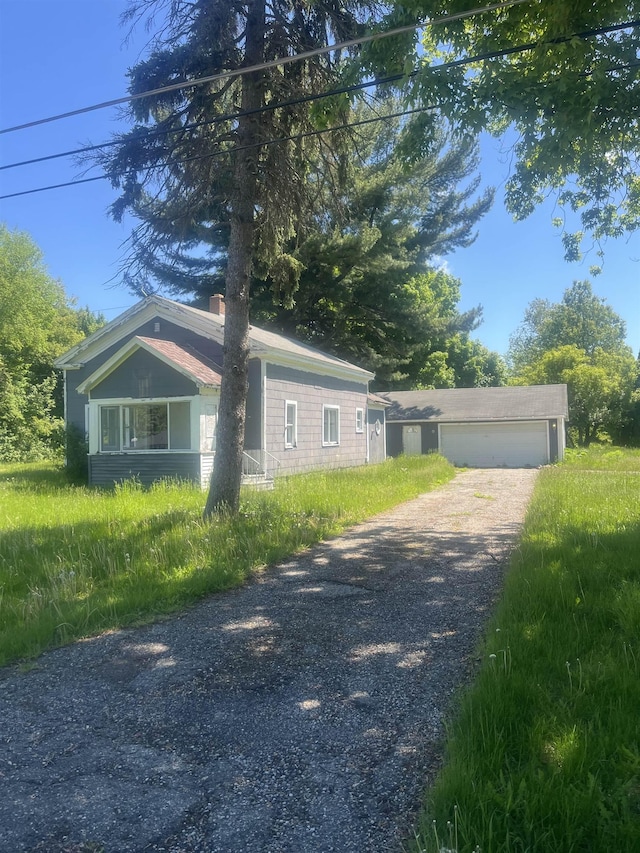 8186 Clio Rd, Mount Morris, MI 48458 - view of side of home with gravel driveway, a chimney, and a garage