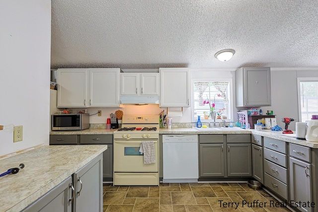 1281 E Pontaluna Rd Lot 113, Norton Shores, MI 49456 - kitchen with white appliances, under cabinet range hood, gray cabinetry, a sink, and light countertops