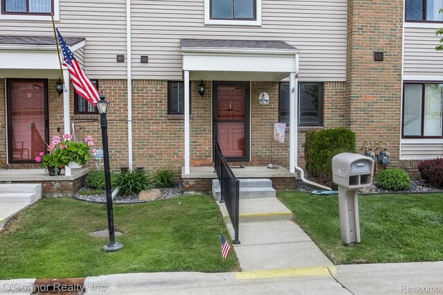 1660 River Rd Unit 52, Marysville, MI 48040 - view of exterior entry with a yard and brick siding