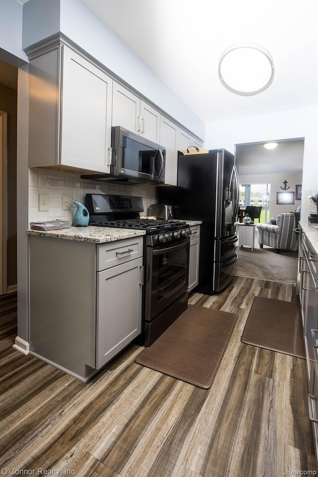 1660 River Rd Unit 52, Marysville, MI 48040 - kitchen with black range with gas cooktop, dark wood finished floors, gray cabinetry, stainless steel fridge with ice dispenser, and backsplash
