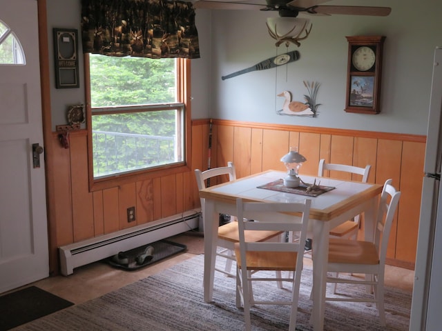 6248 Howard St, Gladwin, MI 48624 - dining room with baseboard heating, wainscoting, and a ceiling fan