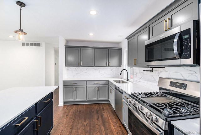 1508 Gardenia Ave, Royal Oak, MI 48067 - kitchen featuring stainless steel appliances, a sink, light countertops, dark wood finished floors, and recessed lighting