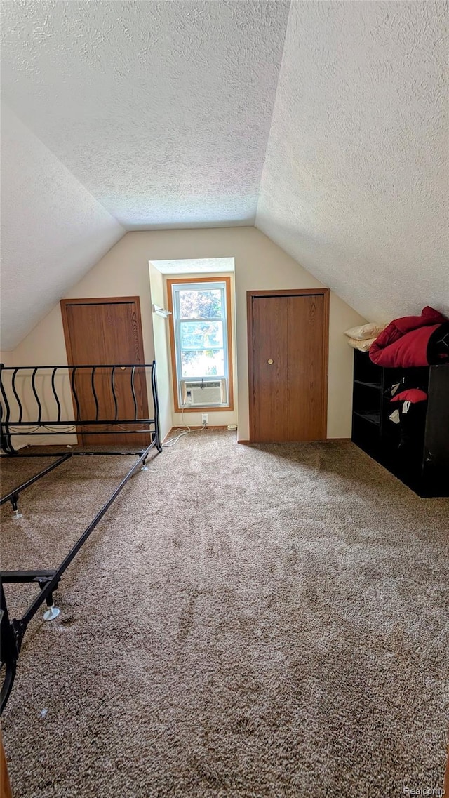 703 Queen St, Owosso, MI 48867 - bonus room featuring a textured ceiling, vaulted ceiling, cooling unit, and carpet floors
