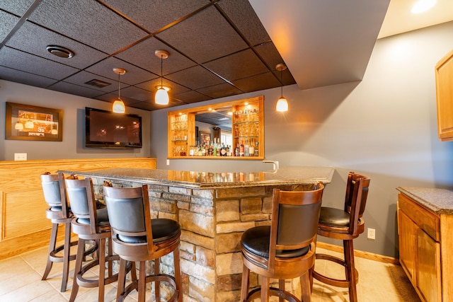 1050 Long Leaf Ct, Brighton, MI 48116 - indoor wet bar with a paneled ceiling, hanging light fixtures, light tile patterned floors, and baseboards