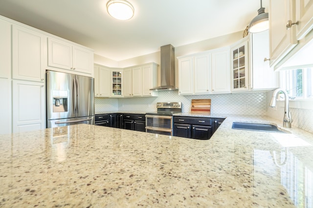 1050 Long Leaf Ct, Brighton, MI 48116 - kitchen with stainless steel appliances, wall chimney range hood, light stone countertops, a sink, and decorative backsplash