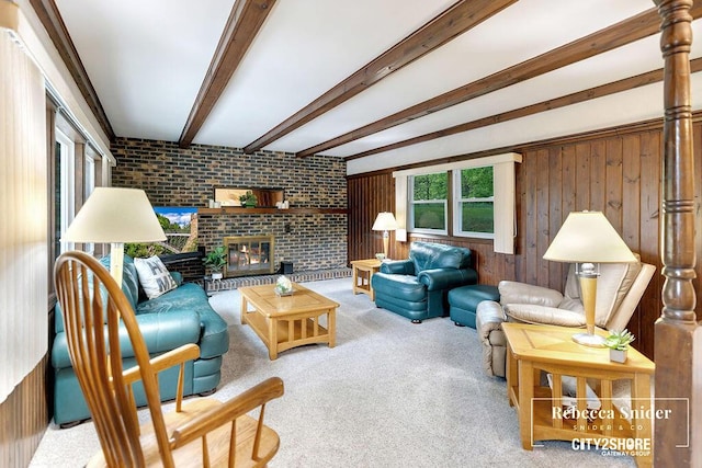 9409 Whitneyville Ave SE, Alto, MI 49302 - living room featuring brick wall, carpet, beam ceiling, wooden walls, and a fireplace